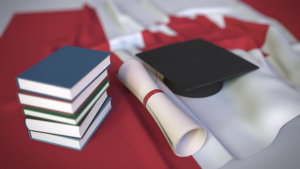 Chapéu de formatura e livros em cima da bandeira canadense